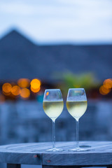 Two glasses of tasty white wine at sunset 