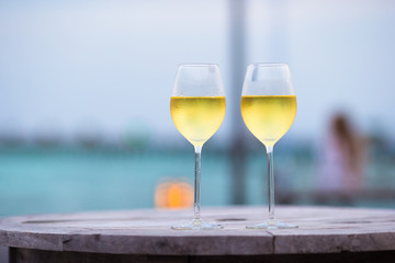 Two glasses of tasty white wine at sunset 