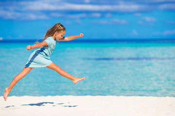 Adorable little girl running during beach vacation 