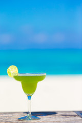 Green tasty cocktail on tropical white beach