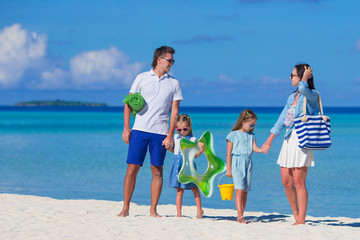 Happy family during summer vacation on white beach