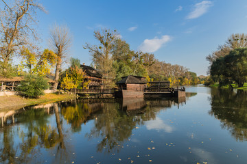 Fototapeta na wymiar Autumn scene with a water mill on boat in Slovak town Kolarovo.