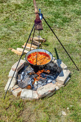 Hungarian goulash cooking outdoor on fire.