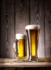 Tall glass and mug of light beer with foam