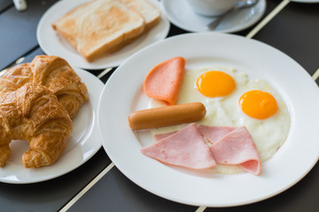 Ham breakfast served with coffee, toast and salads that taste go