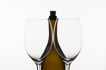 Two empty glasses of wine and brown bottle