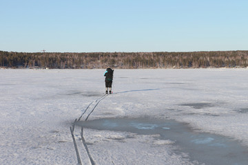 The man the traveler  skiing on the thawing river in the spring