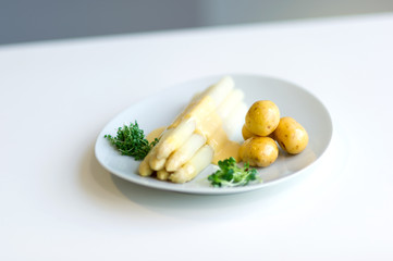 Spargelteller mit Kartoffeln und Hollandaise Sauce.