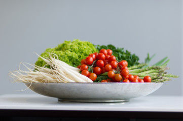 Bunter großer Gemüsekorb mit Tomaten, Salaten und Rettich.