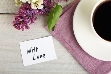 With love note and cup with coffee and lilac