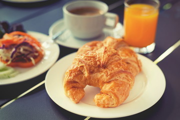 Croissant Breakfast served with black coffee and breakfast menu.