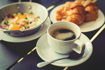 Croissant Breakfast served with black coffee and breakfast menu.