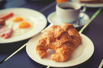 Croissant Breakfast served with black coffee and breakfast menu.