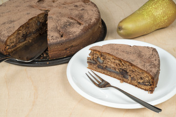 chocolate cake with pears on a wood table