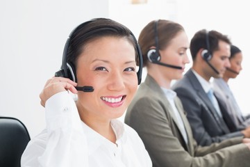 Business people with headsets using computers