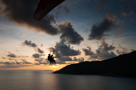 Paraglider flying at the sunset time at the shore