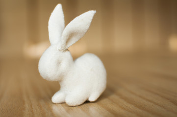 White rabbit on wooden table. Handmade stuffed toy.