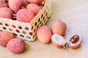 Fresh lychee in bamboo basket on a wooden background