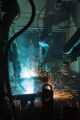 A team of robots welding in automobile parts industry.