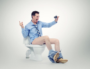 Funny businessman photographing himself in the toilet