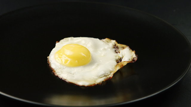 Taking out of a fried eggs from the pan to the dish
