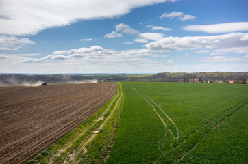 Fototapeta na wymiar Aerial view of the tractor harrowing the field