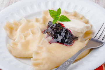 Homemade dumplings with blueberry jam and cream