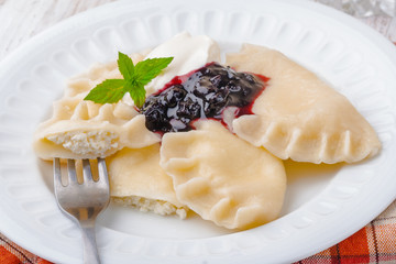 Homemade dumplings with blueberry jam and cream