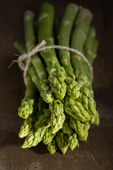 bunch of green asparagus on dark wooden background