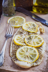 Baked fish with lemon and spices on a baking paper