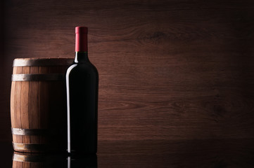 Bottle of red wine and barrel