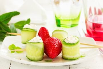 Rolls of cucumber with curd cheese and yogurt with mint.