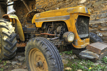 old tractor in front of the stone wall