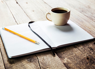 notebook pen and cup of coffee in wood table