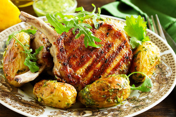 Grilled pork chop on the bone with spicy potatoes.  