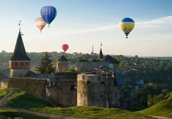 Fototapeta na wymiar Hot baloons fly above medieval castle