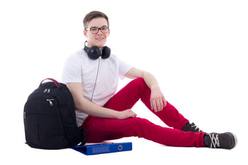 handsome teenage boy with backpack and headphones sitting isolat