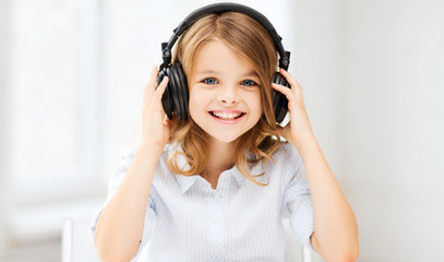 little girl with headphones at home