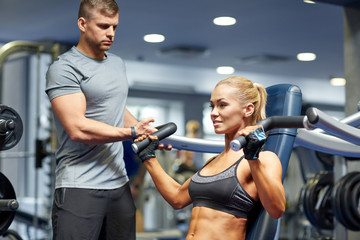 man and woman flexing muscles on gym machine