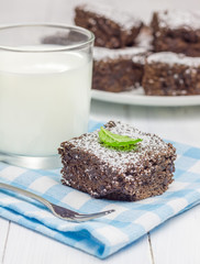 Sugar powdered homemade brownies with glass of milk