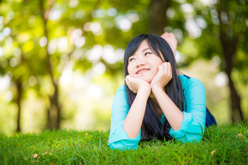 beautiful asian girl  lying down on green grass
