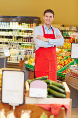 Salesman with arms crossed in supermarket
