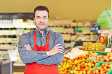 Store manager with arms crossed in supermarket