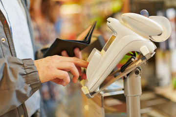 Obraz premium Man typing password at supermarket checkout