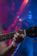 Close up of a guitarist and a saxophone at the background