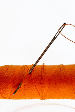 needles and orange color thread