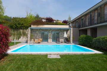 residence with nature stone walls and turquois swimming pool