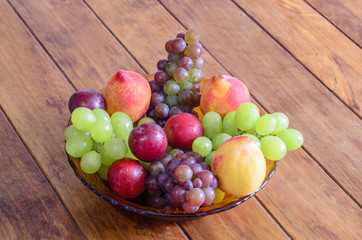Bowl with fresh,healthy and delicious fruits  on wooden table.