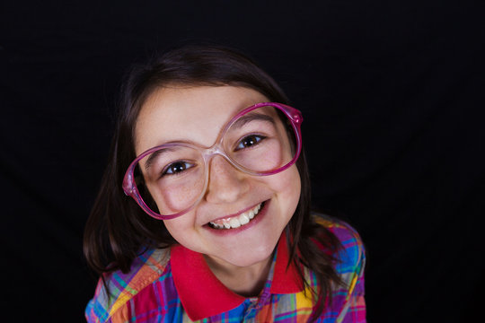 Smiling Happy, little girl, looking at camera wearing glasses.Close-up Studio Portrait