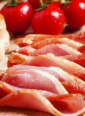 Pork smoked ham and tomatoes on the board, selective focus